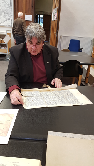 A photo of Jean Roefstra studying an antique document